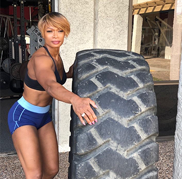 Jennifer Winters rolling a tractor tire during a workout at her gym.
